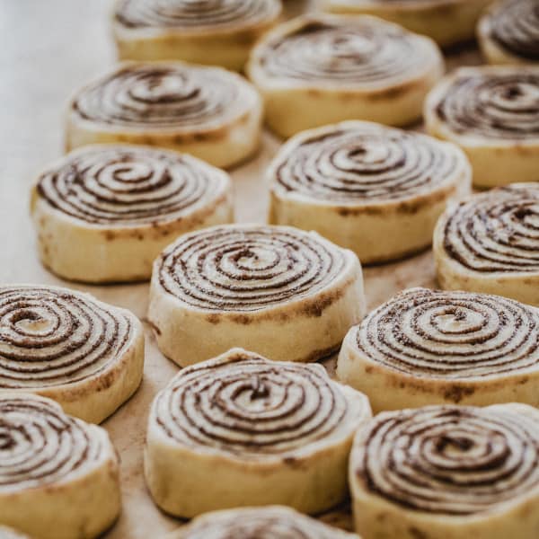 Evenly sliced cinnamon rolls on a cutting board