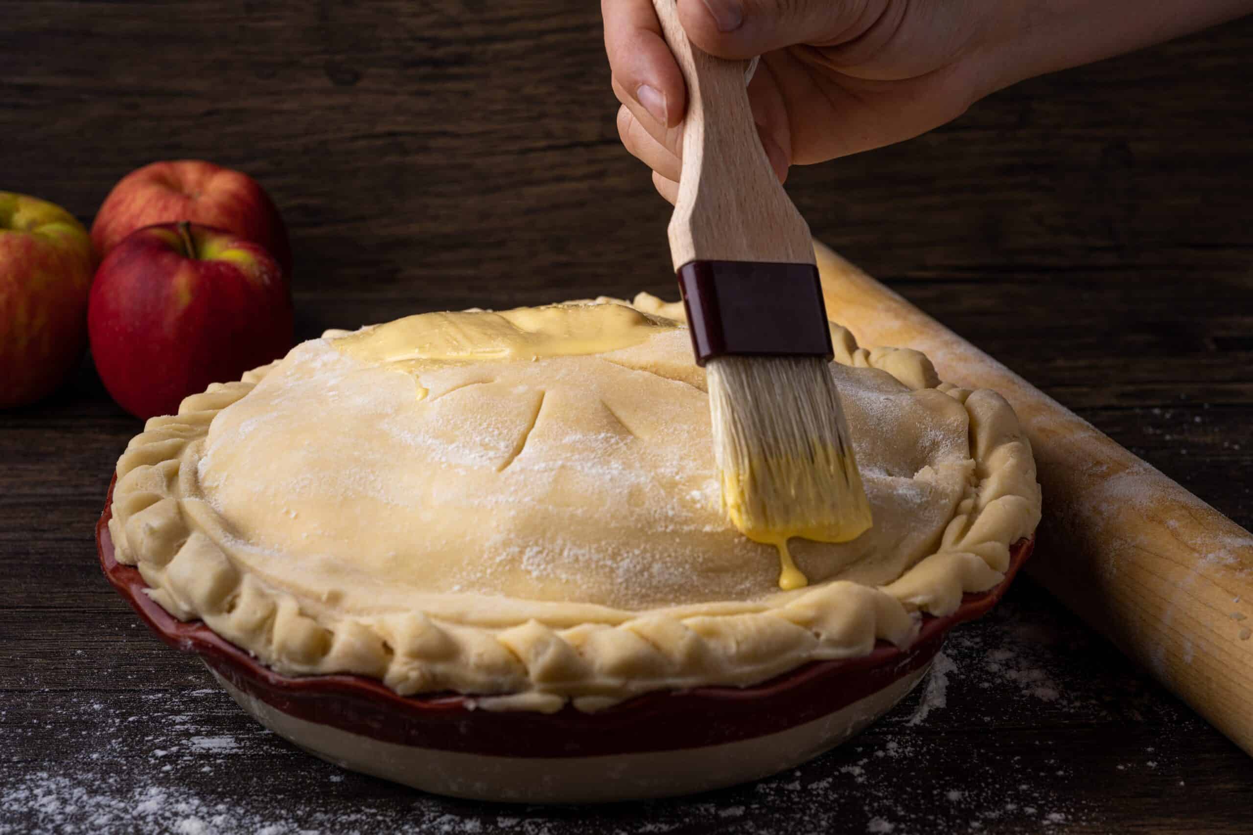 Pie being brushed with an egg wash