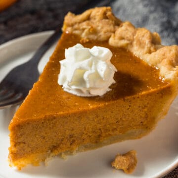 Slice of pumpkin pie with whipped cream