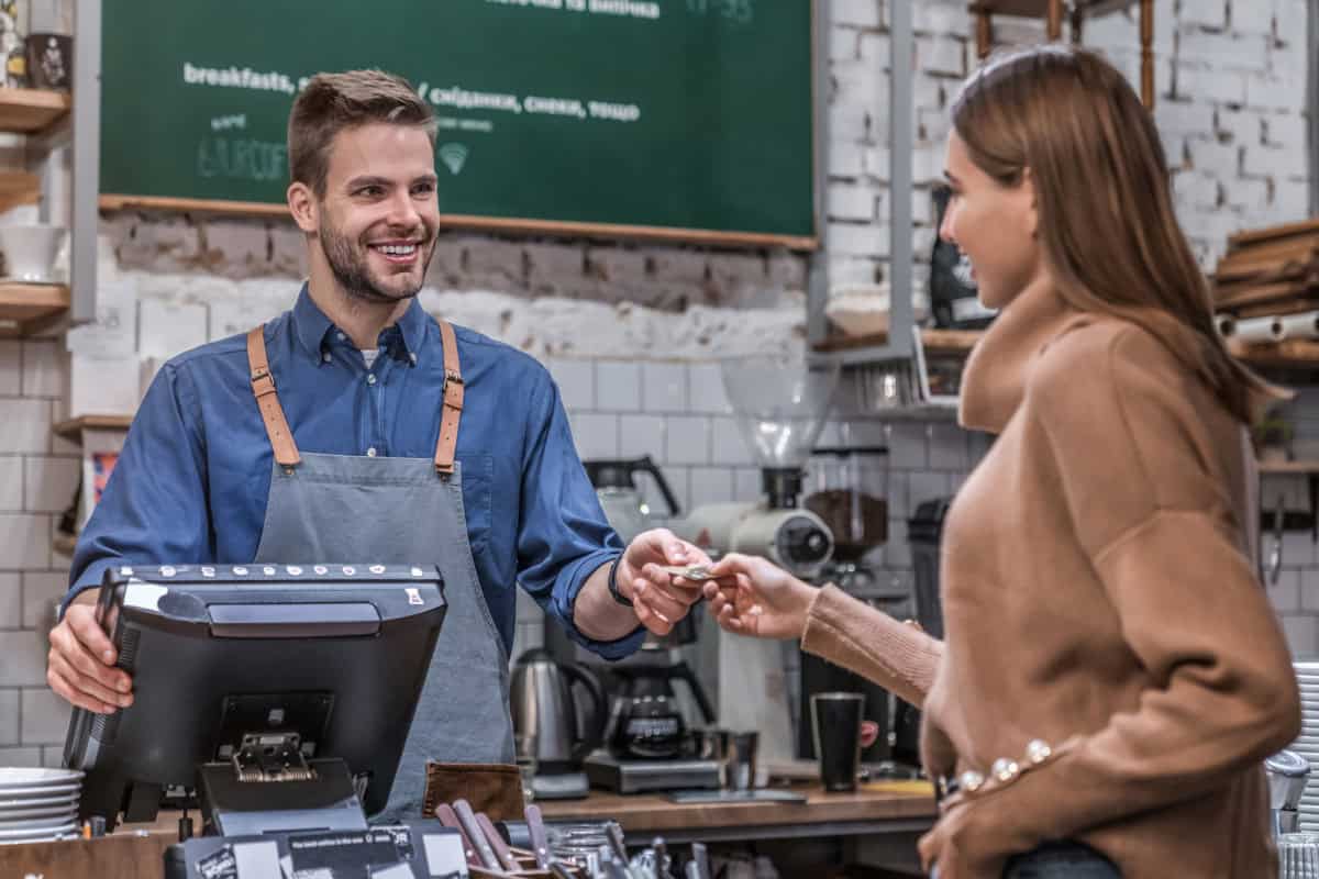 A staff person assists a customer at a register